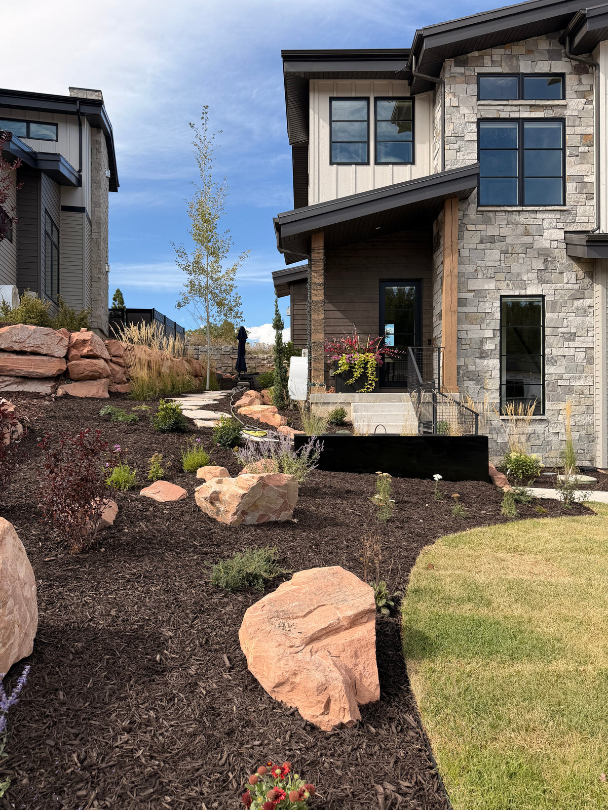Front entrance landscaping with mulch, boulders and lawn in Park City