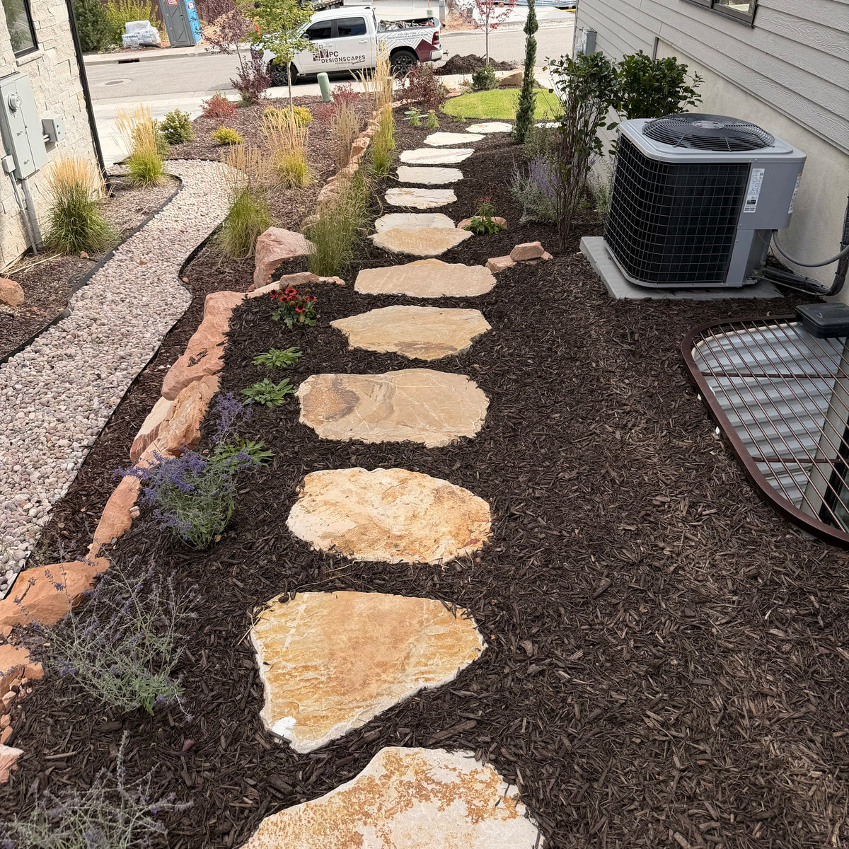 Natural stone pathway through mulch garden beds in Park City