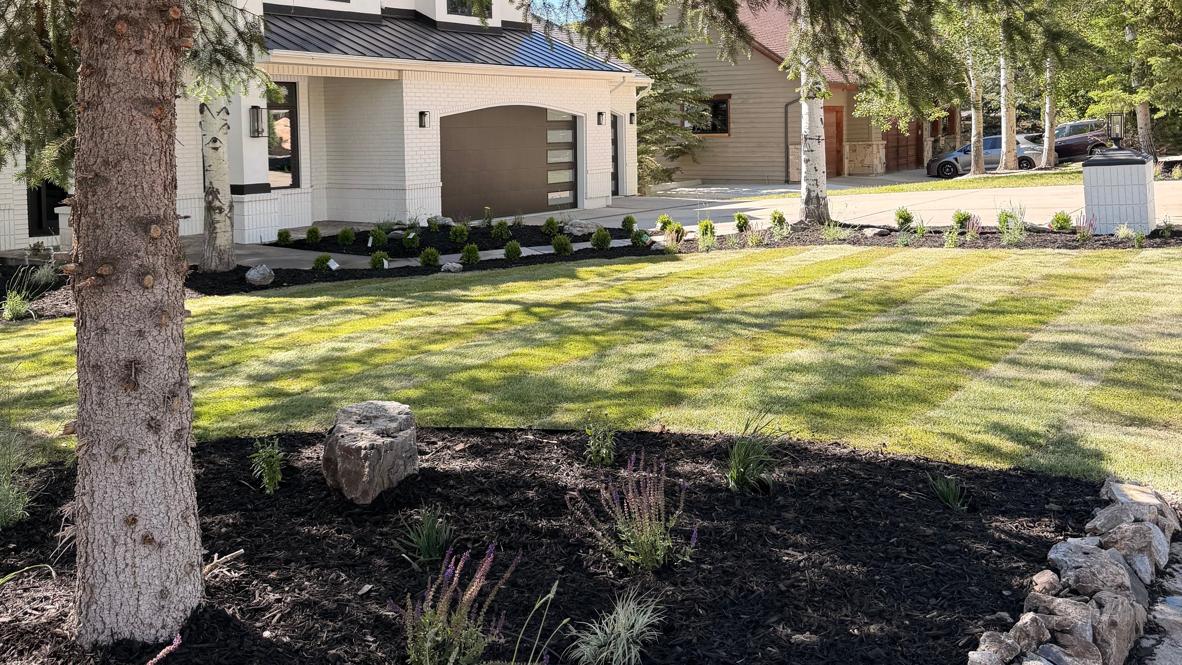 Landscape design in Park City with water-wise plants, mulch, stone, and mountain views