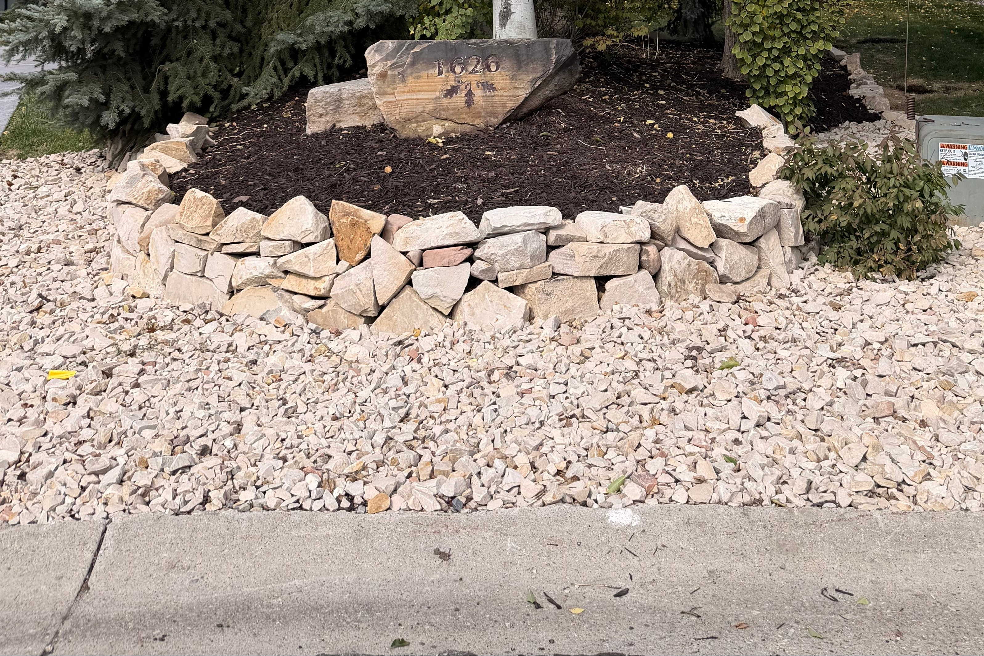 Park City hardscaping project with natural stone border, decorative rock, mulch, and boulder feature.