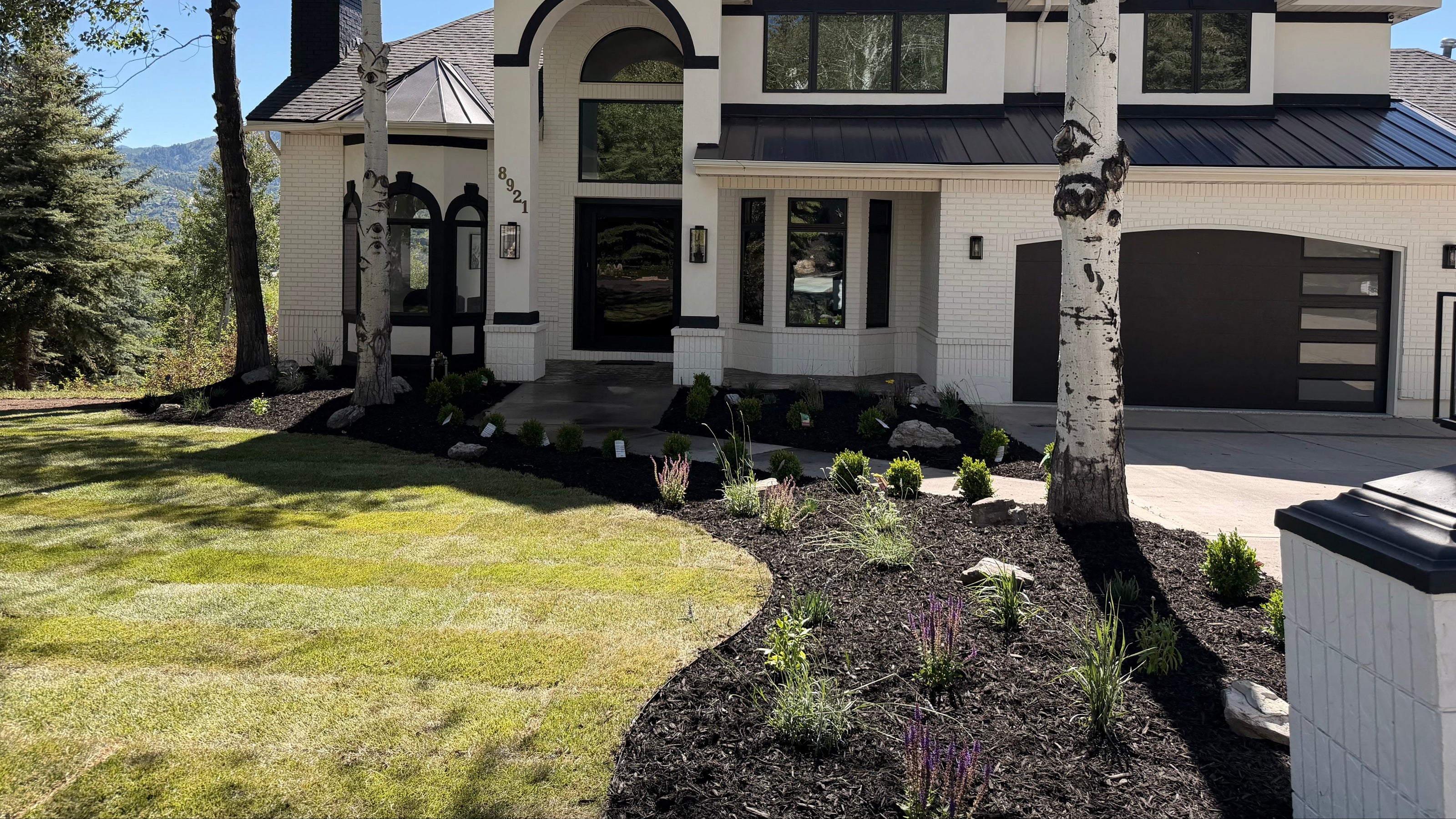 Completed Park City landscape installation with sod, mulch, planting beds, and mountain home curb ap