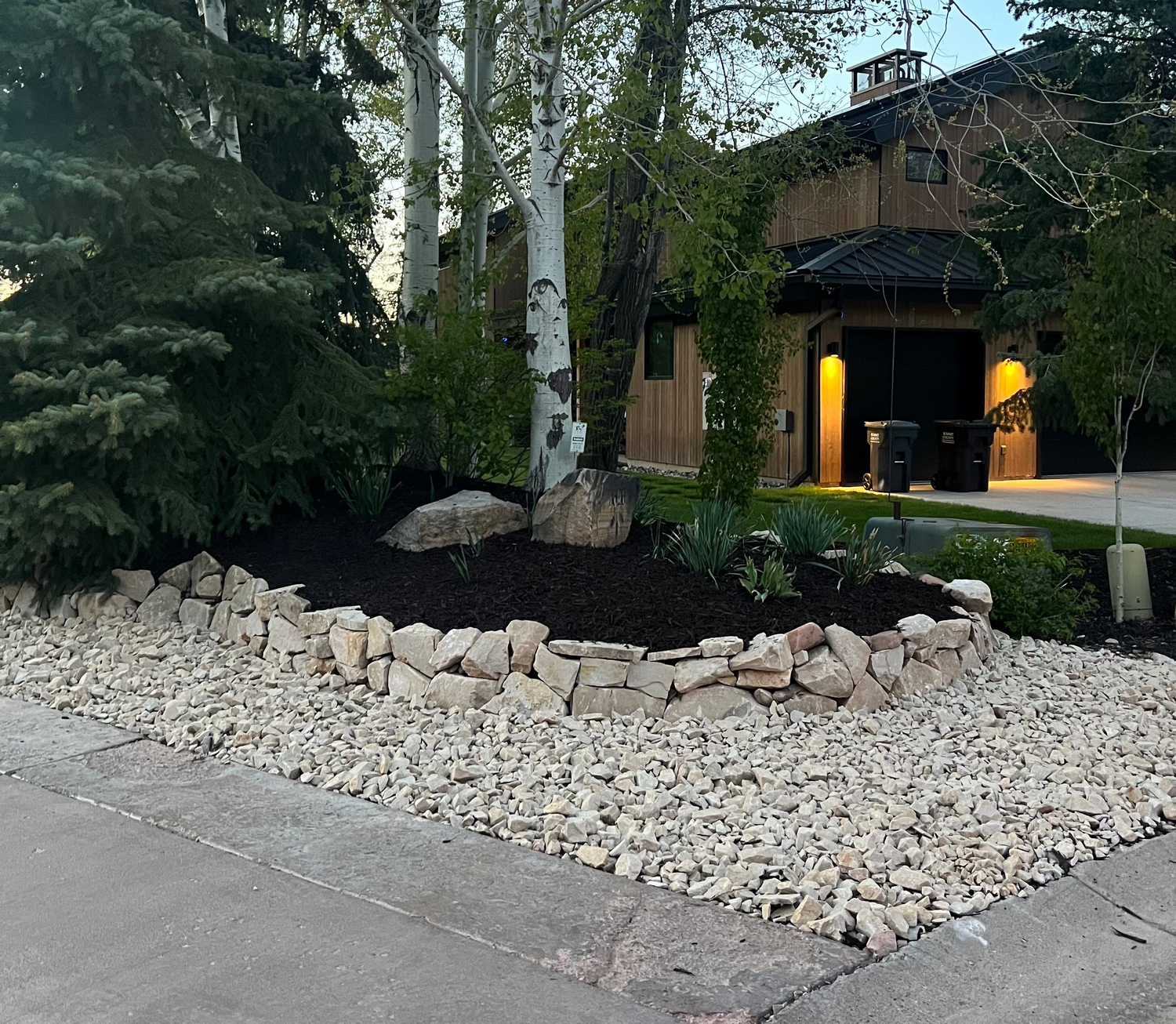 Park City outdoor improvement with decorative rock, natural stone border, mulch, and landscape transitions.