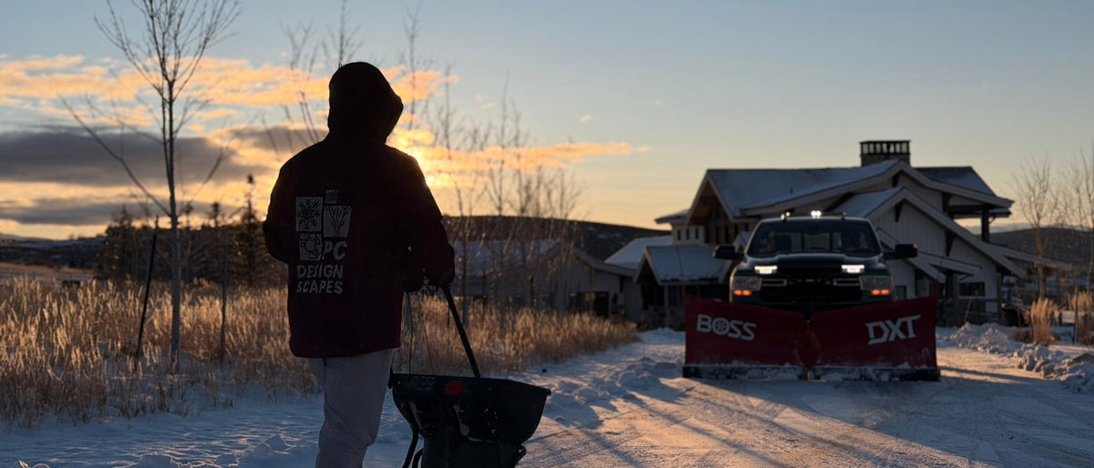 PC DesignScapes crew member with salt spreader and RAM truck with BOSS snow plow at sunset in Park City