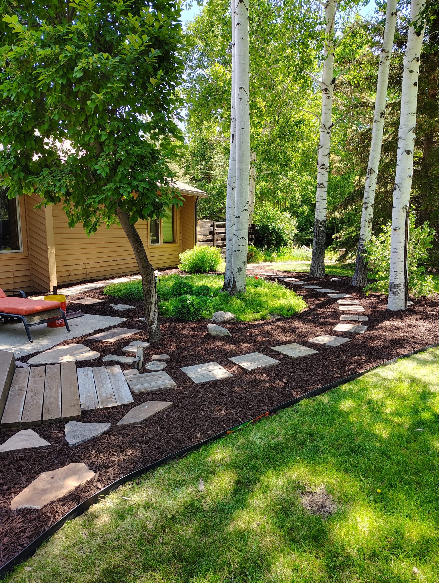 Stone pathway and landscape design with mulch and planting beds in Park City